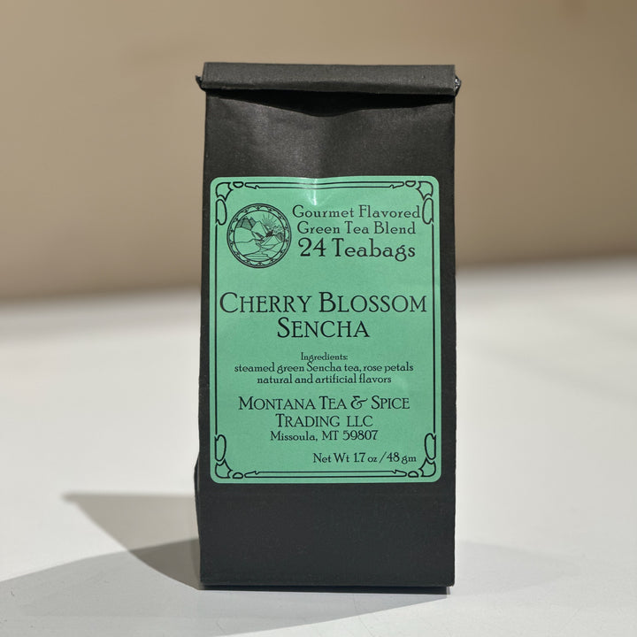 A black tea bag pouch with a light green label reading &