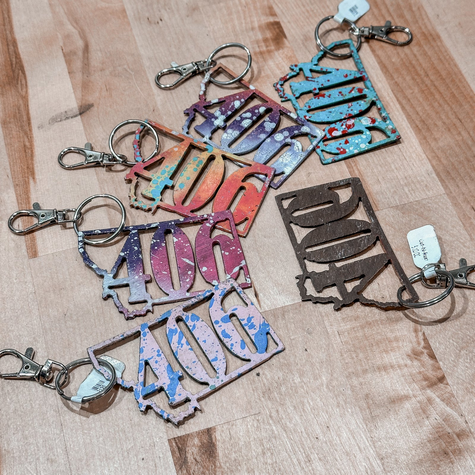 This Montana 406 Metal Keychain showcases a state-shaped design with a the 406 area code cut out of it.