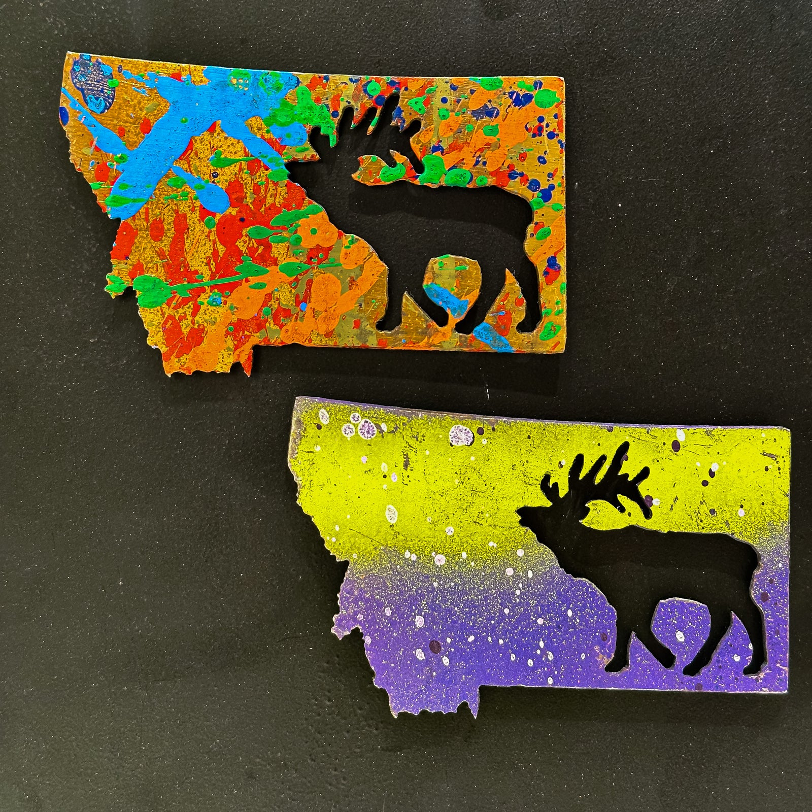 A made in Montana state-shaped cut-out with an elk bugling silhouette embedded in it and a strong back magnet.