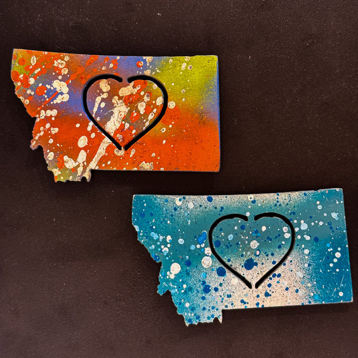 A made in Montana state-shaped cut-out with a heart silhouette embedded in it and a strong back magnet.