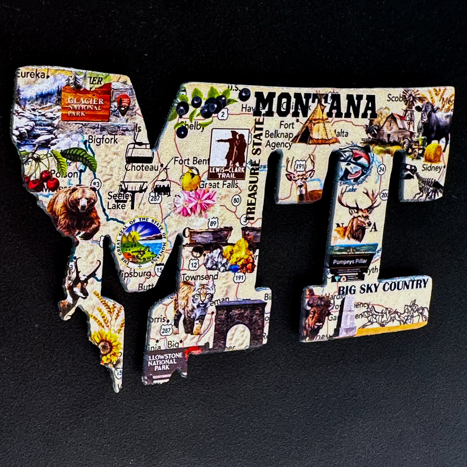 A made in Montana MT and state shaped magnet with a full color map printed on it. Featuring a strong backed magnet.