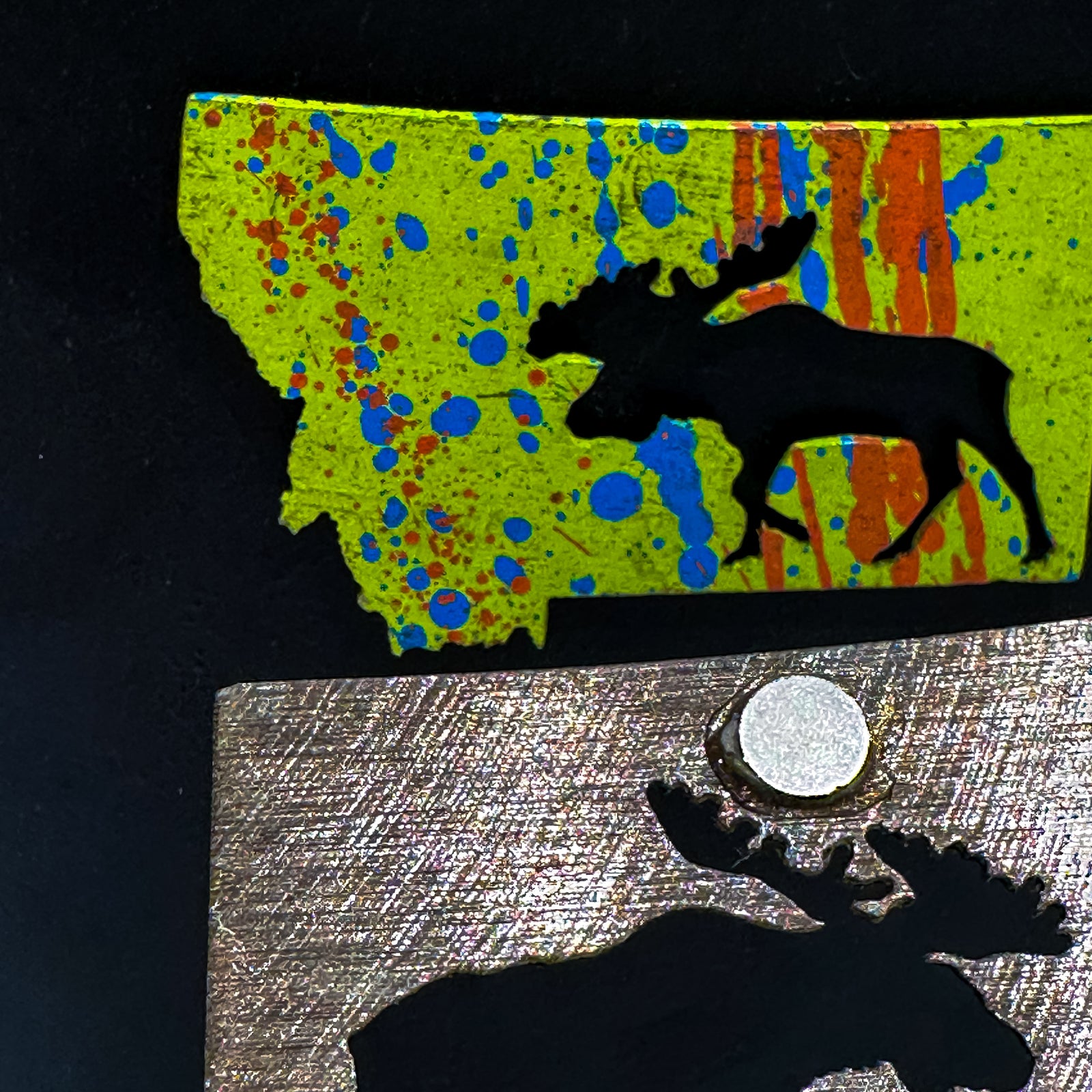 A made in Montana state-shaped cut-out with a moose silhouette embedded in it and a strong back magnet.