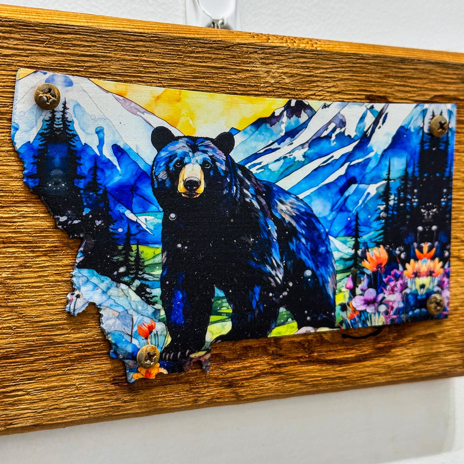 This Metal and wood plaque is in the shape of Montana with a vibrant print of a Black Bear. Made in Montana.