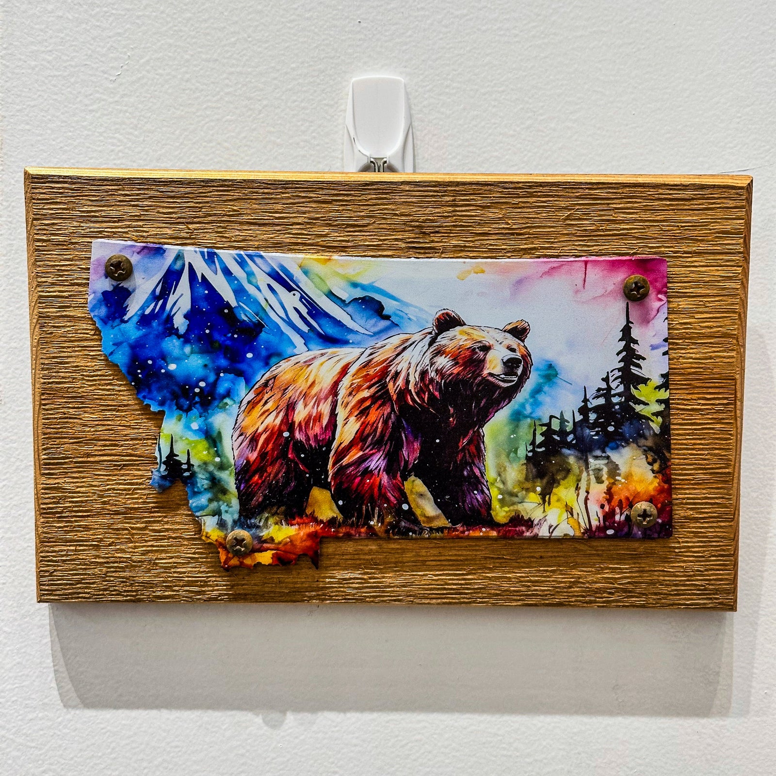 This Metal and wood plaque is in the shape of Montana with a vibrant print of a Grizzly Bear. Made in Montana.