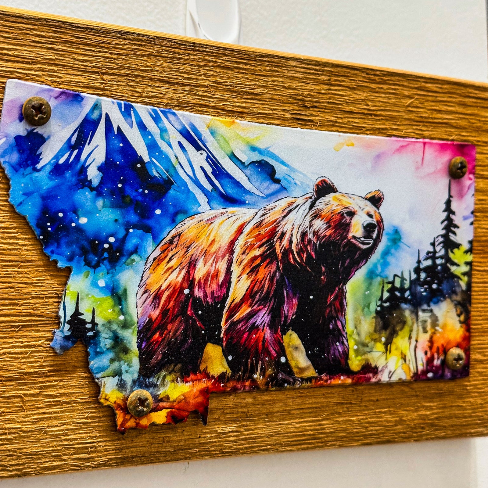 This Metal and wood plaque is in the shape of Montana with a vibrant print of a Grizzly Bear. Made in Montana.