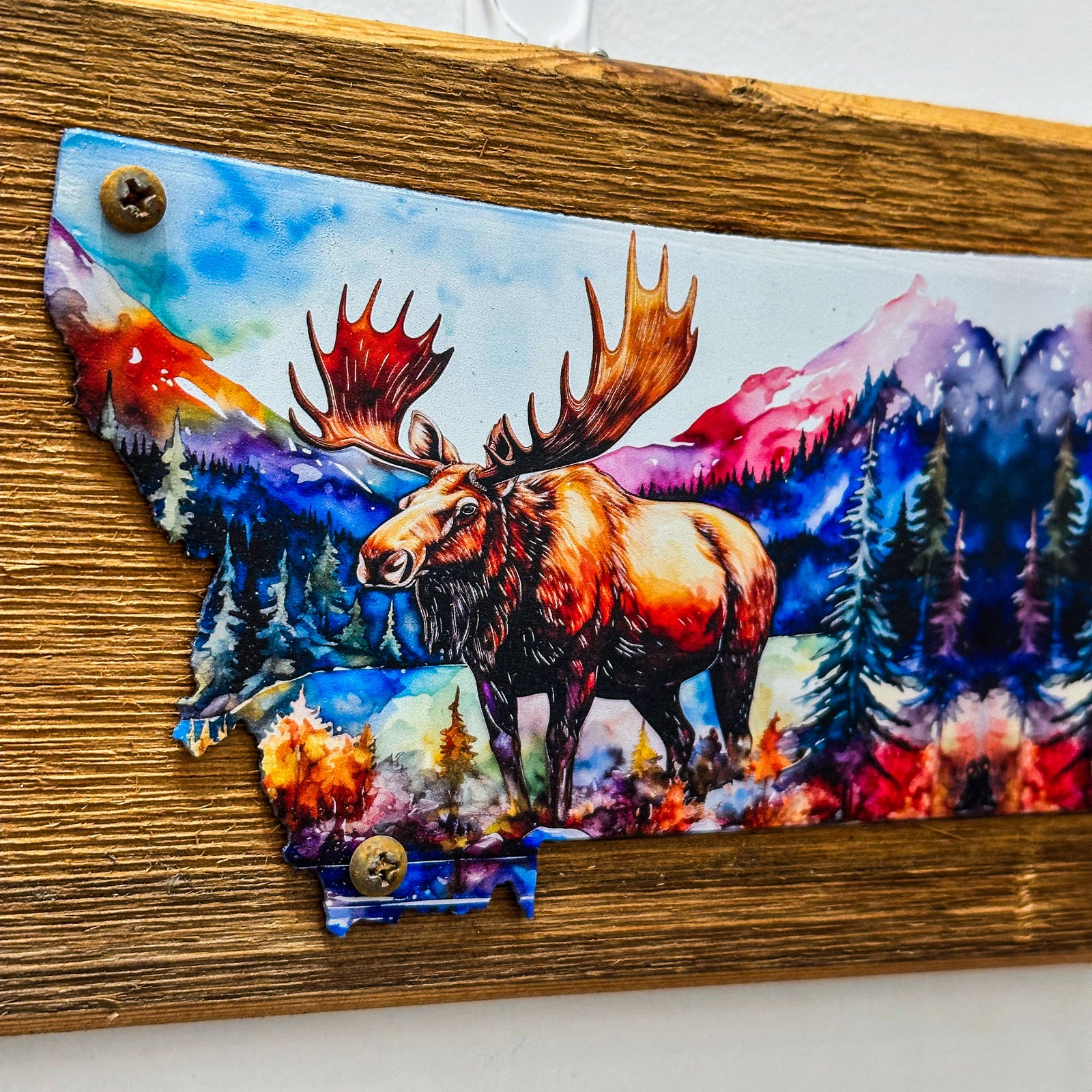 This Metal and wood plaque is in the shape of Montana with a vibrant print of a Moose. Made in Montana.