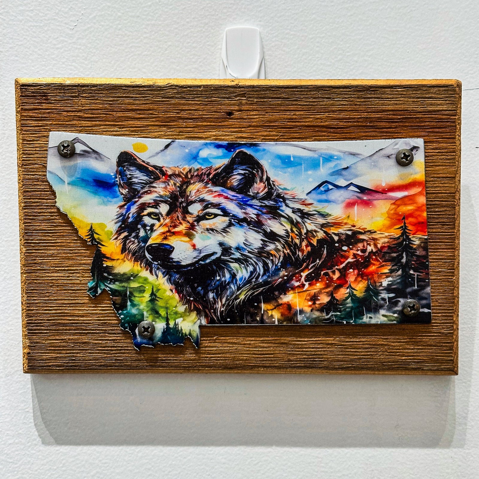 This Metal and wood plaque is in the shape of Montana with a vibrant print of a Wolf. Made in Montana.