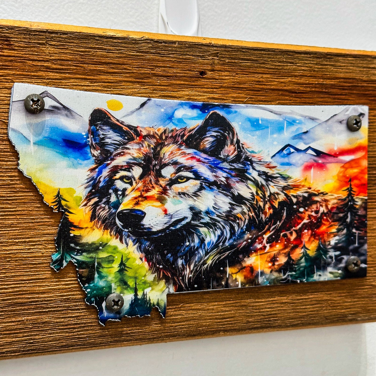 This Metal and wood plaque is in the shape of Montana with a vibrant print of a Wolf. Made in Montana.