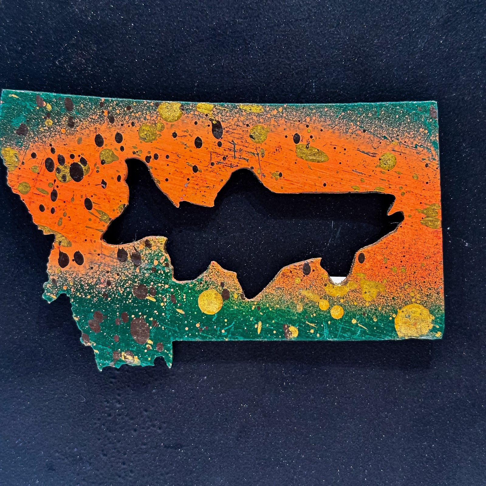 A made in Montana state-shaped cut-out with a Trout silhouette embedded in it and a strong back magnet.