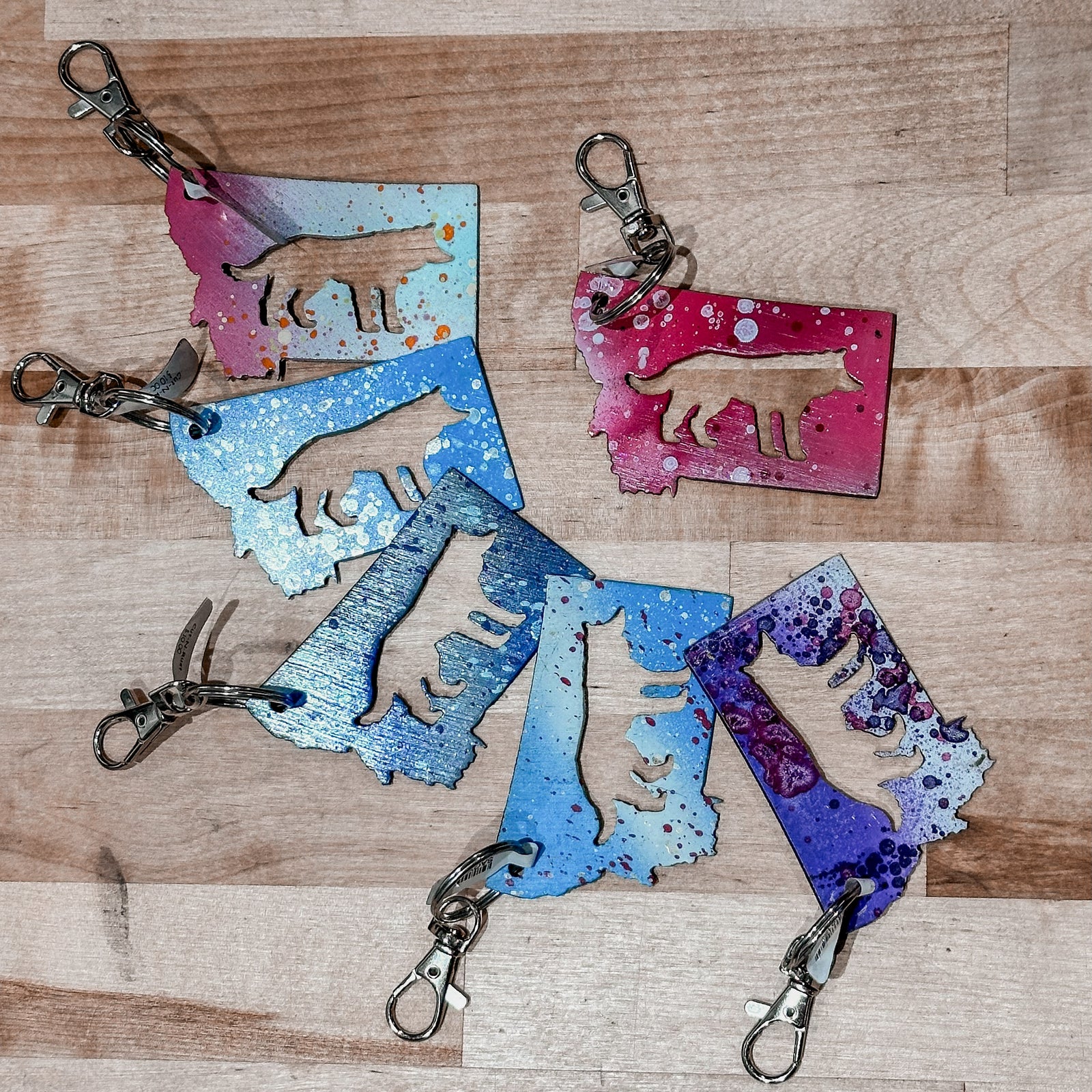 This Montana Wolf Metal Keychain showcases a state-shaped design with a wolf silhouette cut out of it.