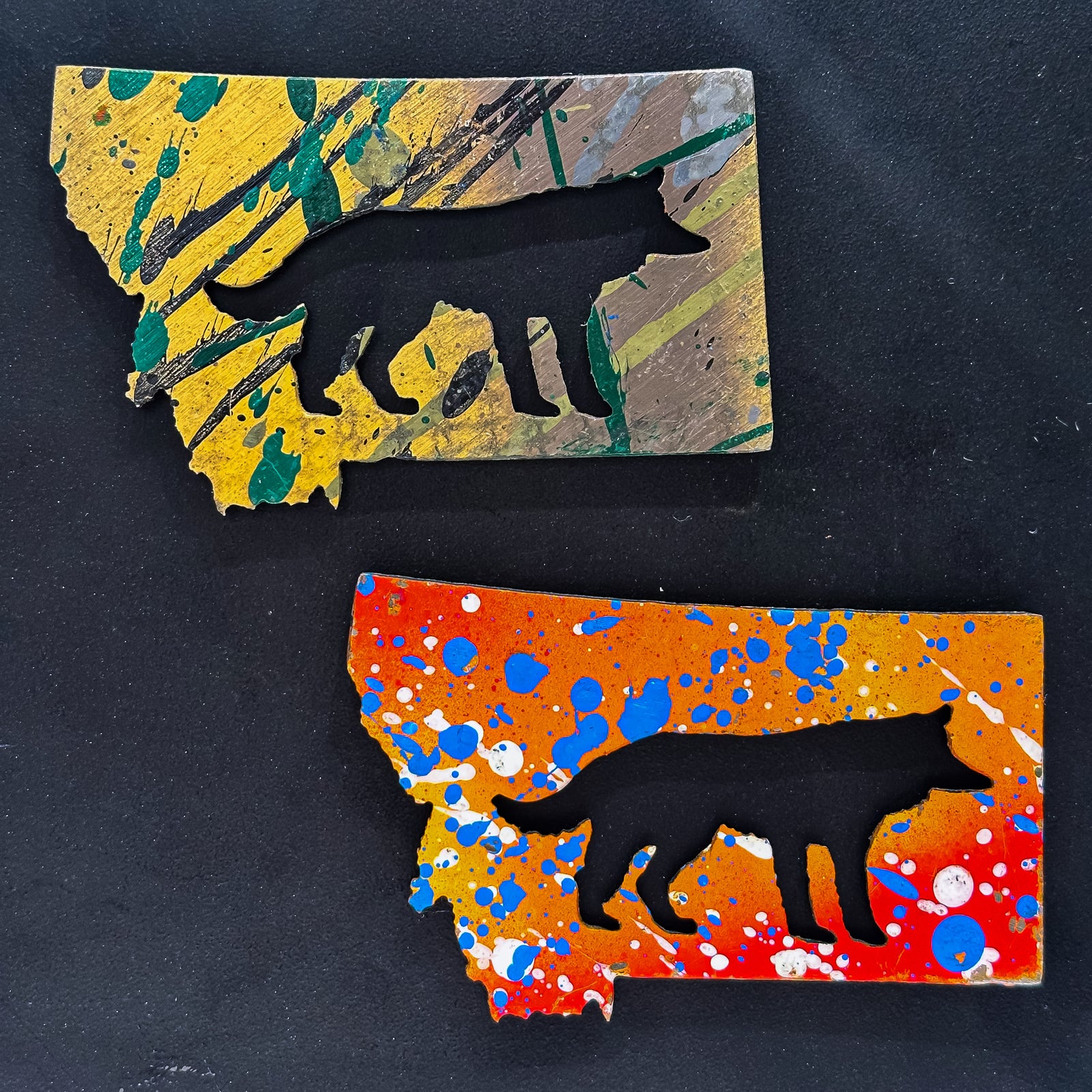 A made in Montana state-shaped cut-out with a silhouette of a wolf embedded in it and a strong back magnet.