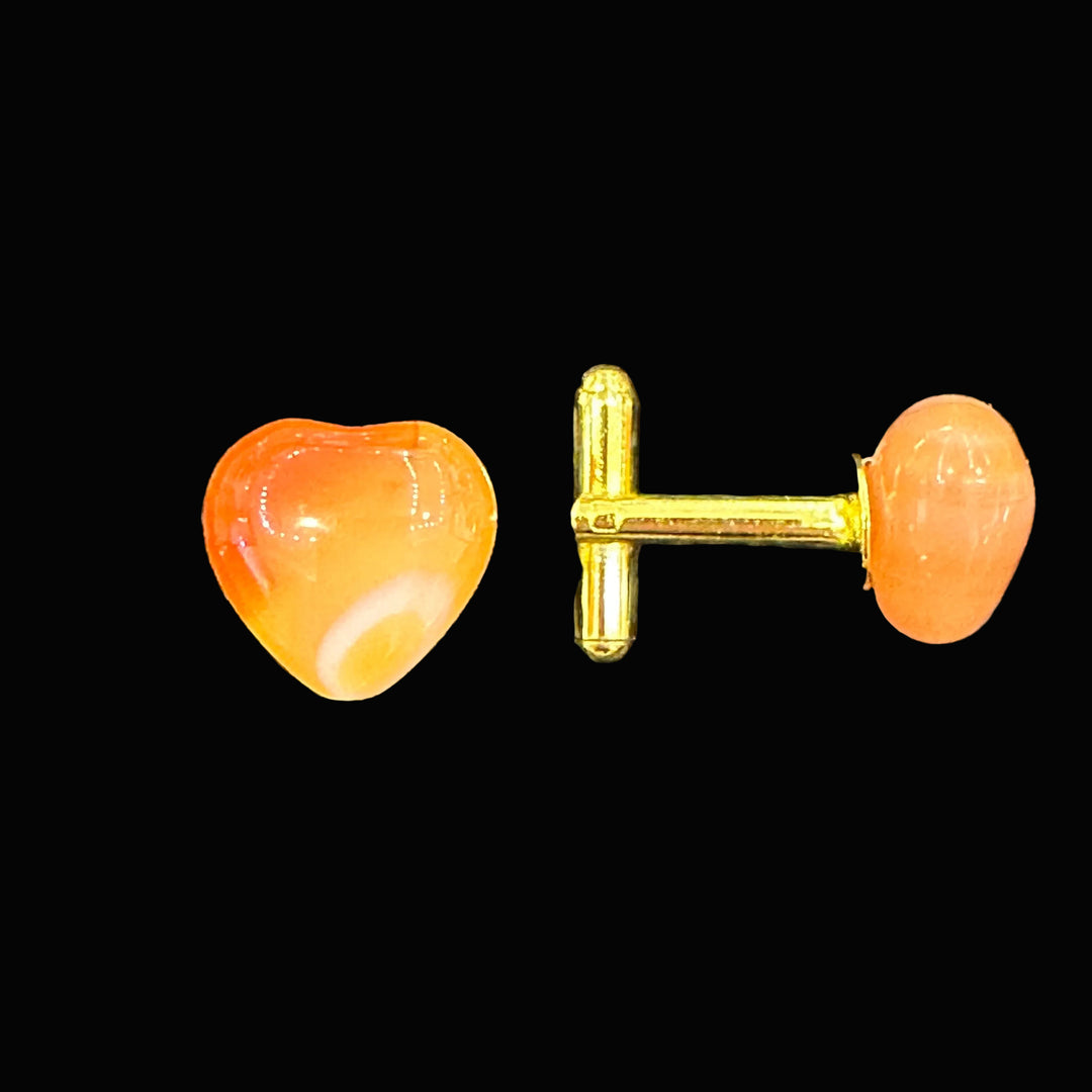 Carnelian gemstone heart cuff links on a black background