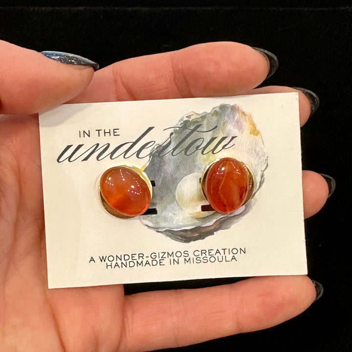 Carnelian and gold cuff links on a card reading Handmade in Missoula