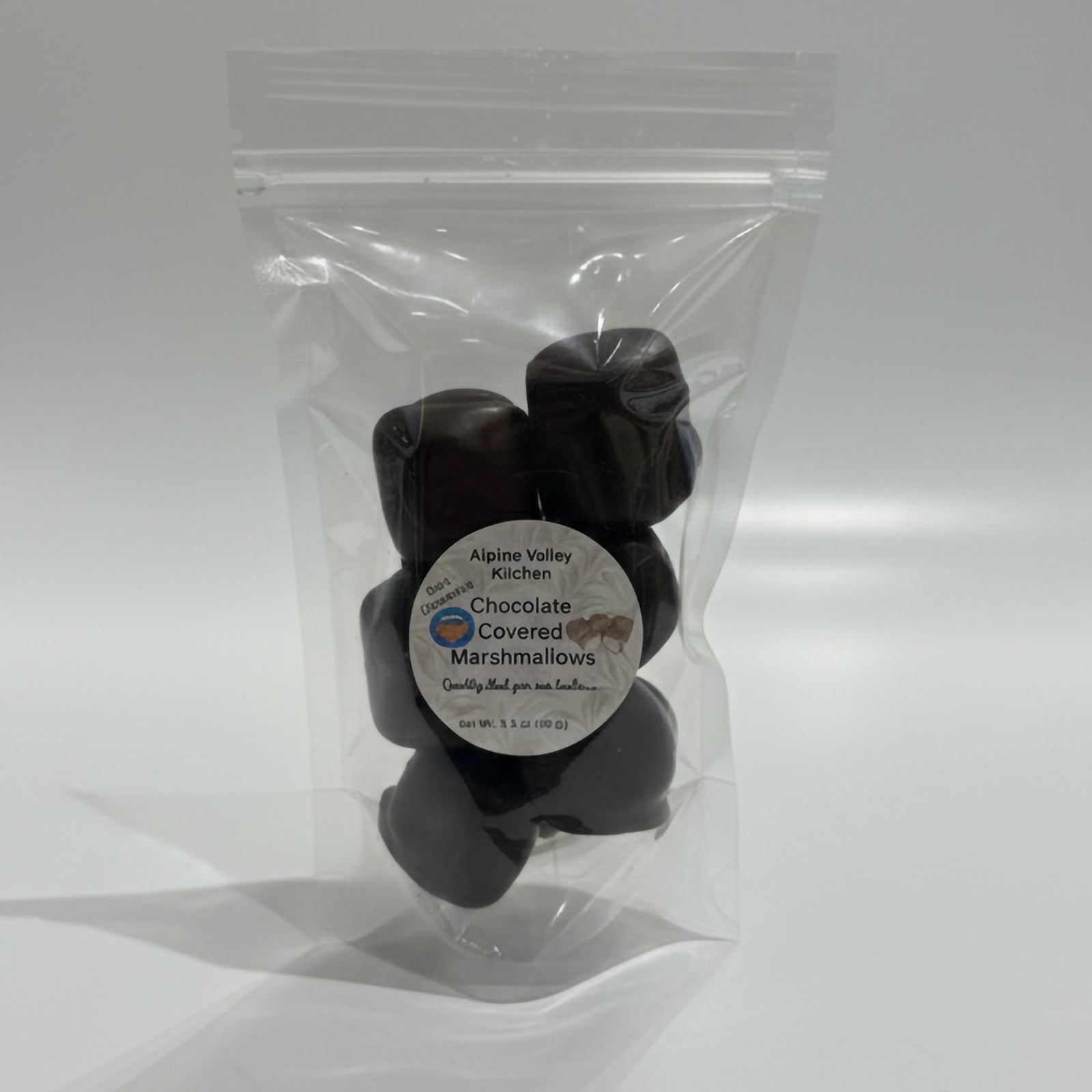 Clear plastic bag with chocolate-covered marshmallows and a label on a white background