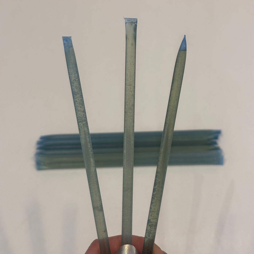 Three light blue coconut flavored honey sticks made in Montana