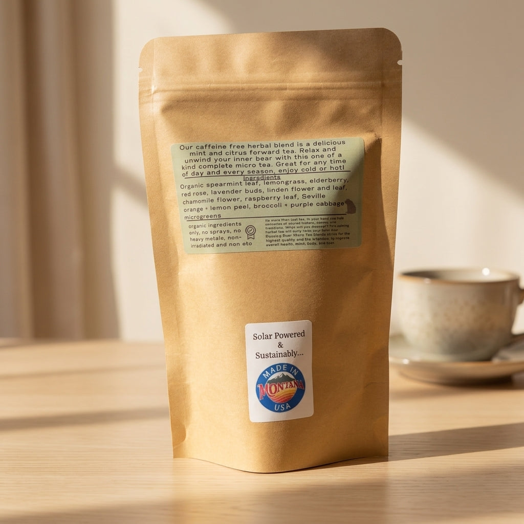 A kraft paper bag of Montana Made caffeine free herbal micro green tea with a blurred cup in the background