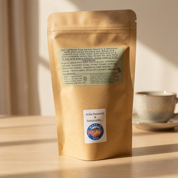 A kraft paper bag of Montana Made caffeine free herbal micro green tea with a blurred cup in the background