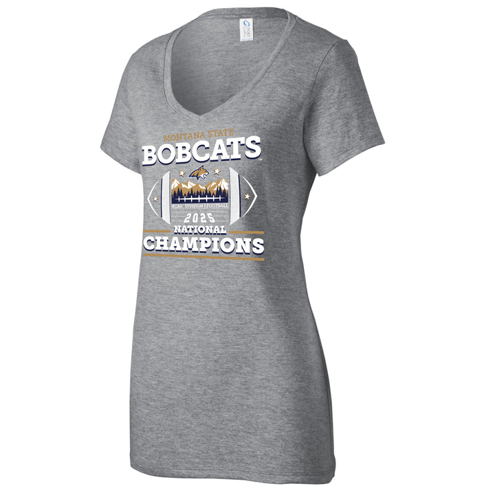 This is a Light Grey short-sleeved V-neck t-shirt with a tapered, feminine fit. The fabric is thin, soft, and smooth to the touch. On the front, there is a large, multi-layered screen-printed graphic. You can feel the distinct edges of the block lettering for "Bobcats" and "Champions," along with the slightly raised texture of the central football-shaped emblem that contains sharp mountain peaks.
