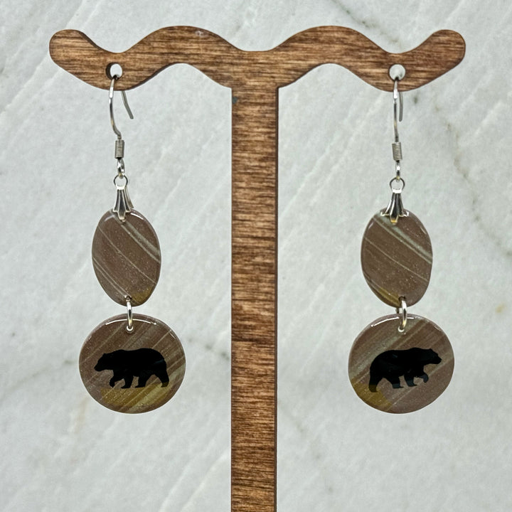 Pair of Small Dangle Earrings with Bears by Bitterroot Shining Creations, featuring double drop polymer clay in in various colors with a bear silhouette on the bottom drop (taupe), hanging