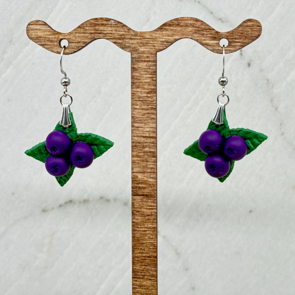 Pair of polymer clay Huckleberry Earrings on stainless steel ear wires by Bitterroot Shining Creations (triple berry design), hanging