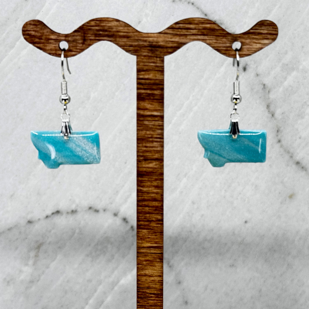 Pair of small, polymer clay Montana Earrings by Bitterroot Shining Creations in assorted sparkly colors (light blue), hanging