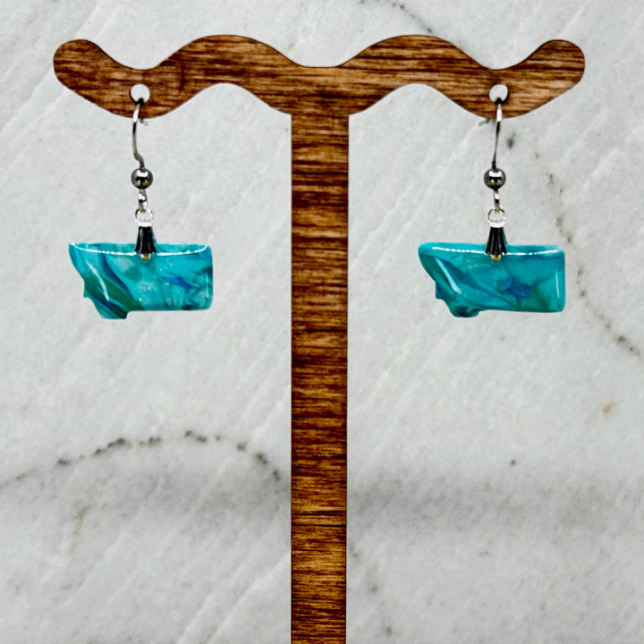 Pair of small, polymer clay Montana Earrings by Bitterroot Shining Creations in assorted sparkly colors (teal), hanging