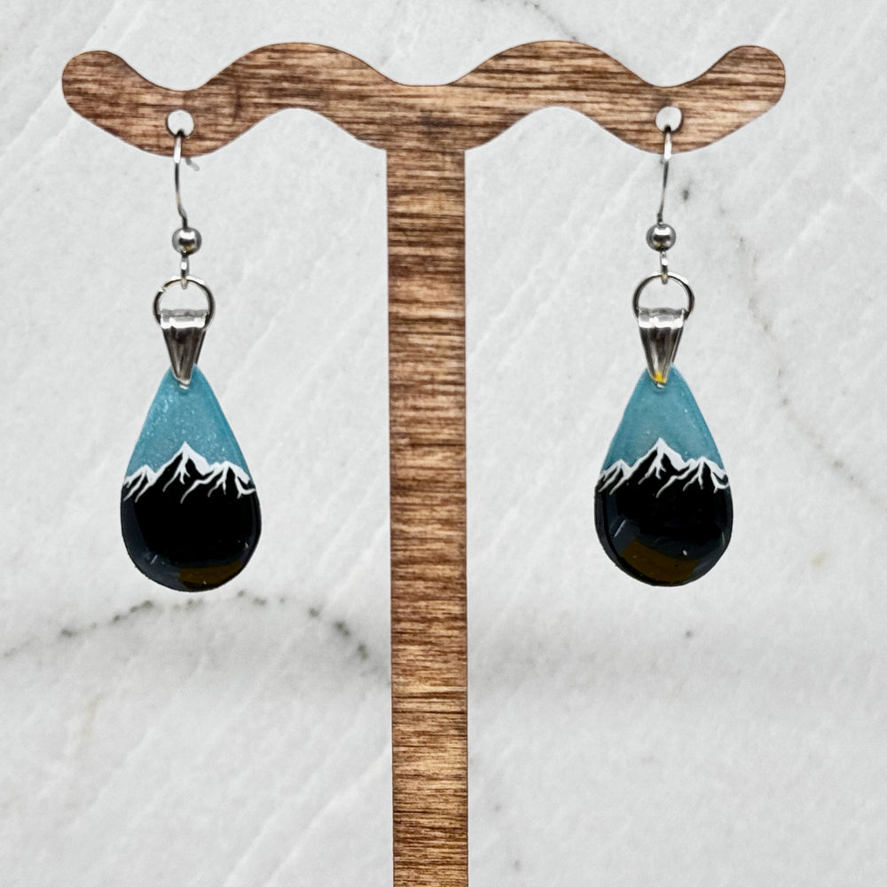 Pair of small, polymer clay Teardrop Earrings with Mountain by Bitterroot Shining Creations (sparkly light blue), hanging