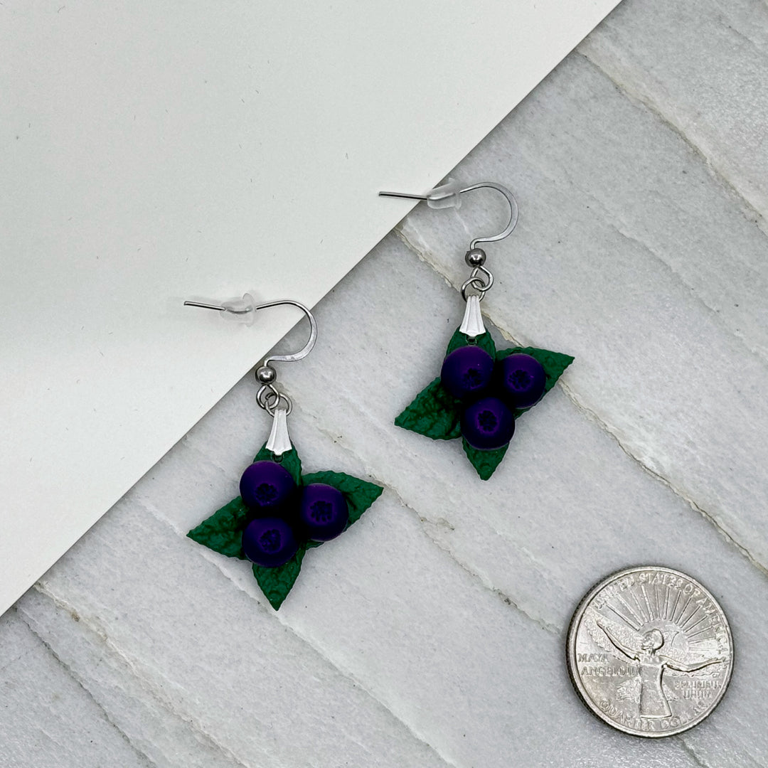 Pair of polymer clay Huckleberry Earrings on stainless steel ear wires by Bitterroot Shining Creations (single berry design), with scale