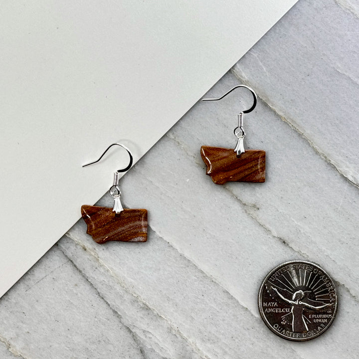 Pair of small, polymer clay Montana Earrings by Bitterroot Shining Creations in assorted sparkly colors (orange), with scale