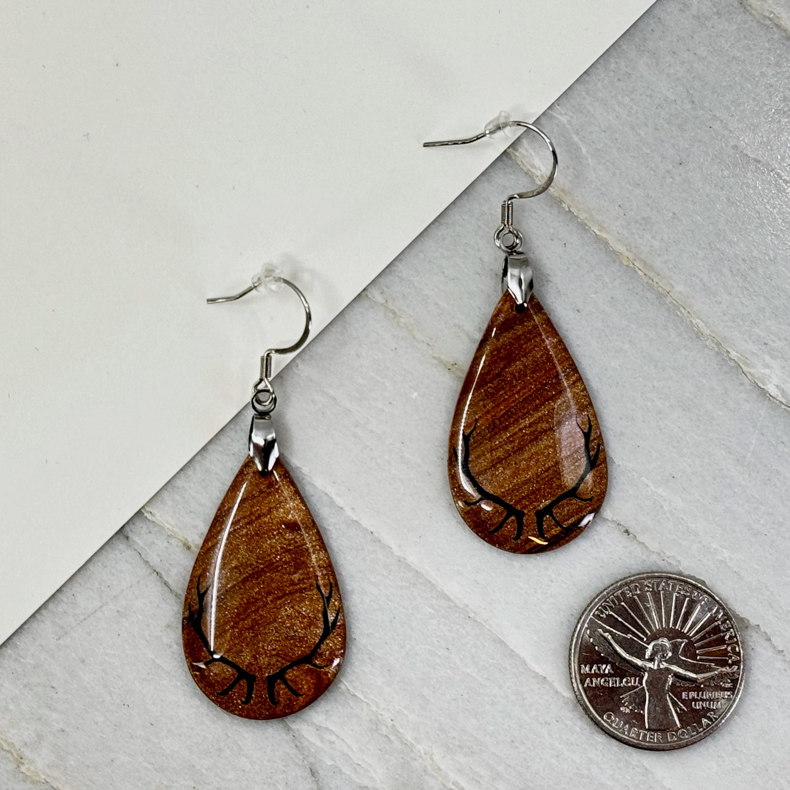 Pair of Large Teardrop Earrings with Antlers, featuring shimmering gold polymer clay teardrops decorated with black antlers, with scale