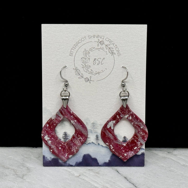 Pair of University of MT Grizzlies Themed polymer clay Arabesque Earrings (large) by Bitterroot Shining Creations, featuring maroon and silver polymer clay, on card
