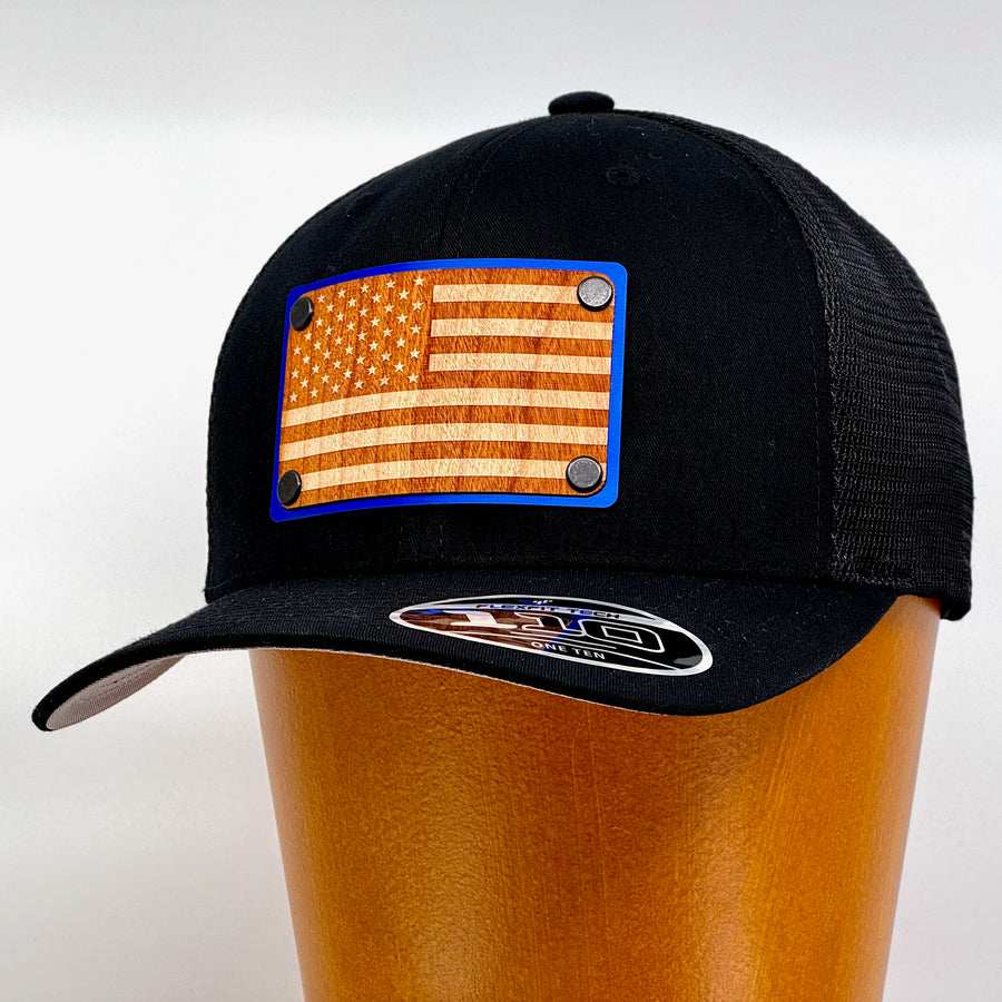 Last Best Supply Co's American Flag Wood & Blue Metal Patch Flexfit Trucker Hat - Black (3/4 view)