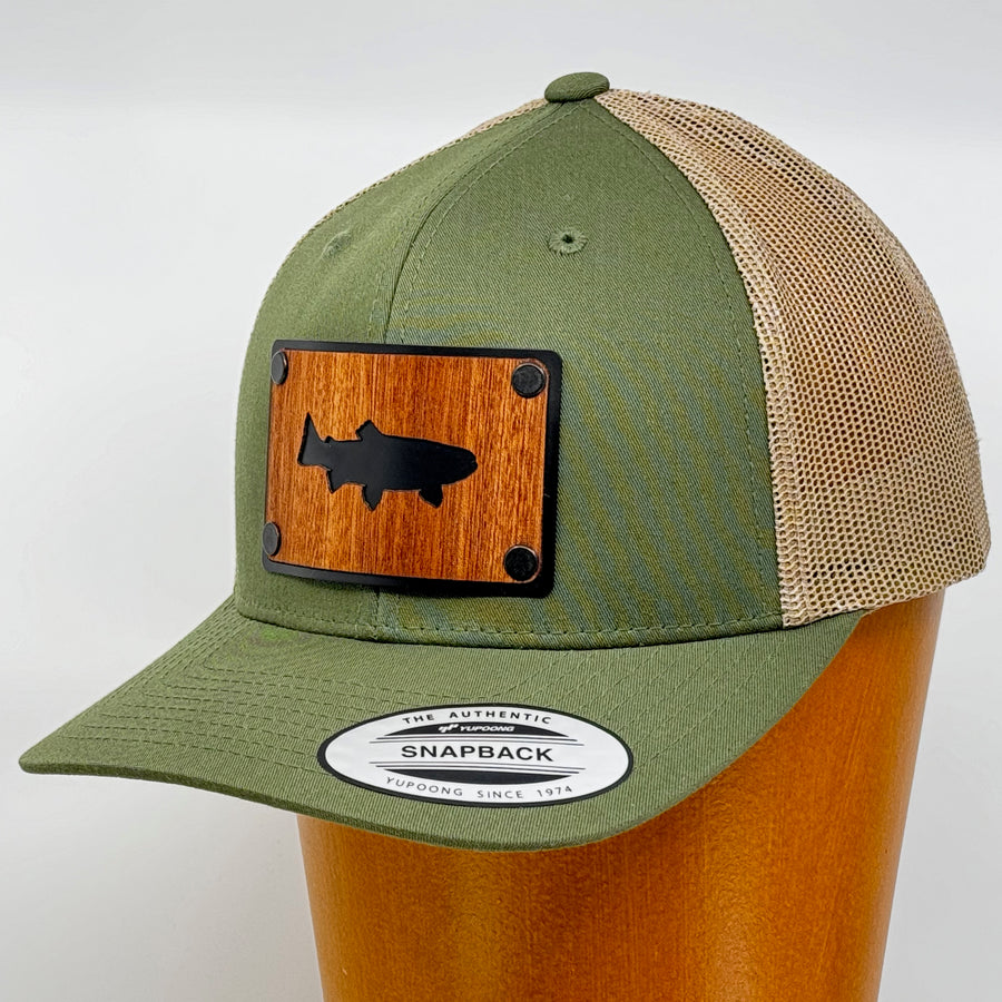 Last Best Supply Co's Olive Green & Khaki Mesh Mahogany Patchplate Trout Silhouetted Trucker Hat, featuring the silhouette of a trout cut out of mahogany against a black metal patch (3/4 view)