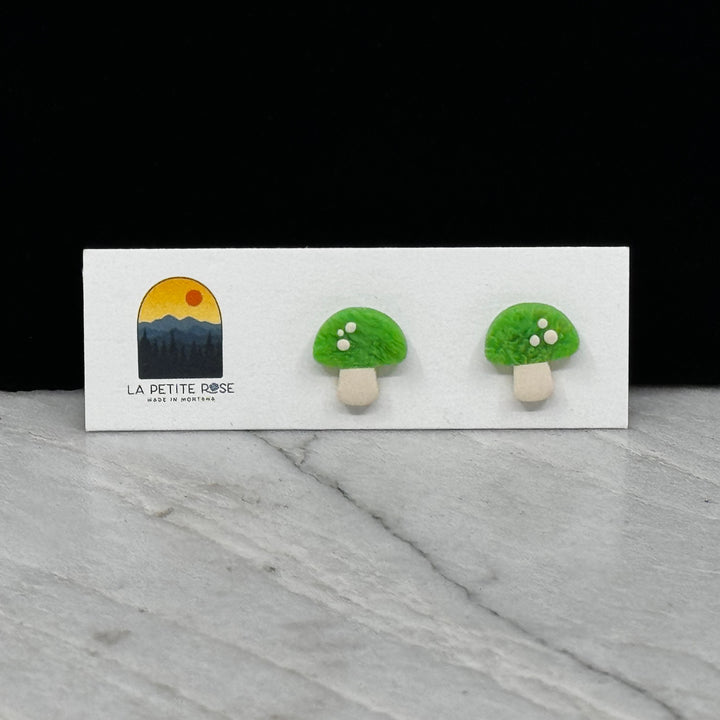 Pair of La Petite Rose Polymer Clay Green Mushroom Stud Earrings, on card
