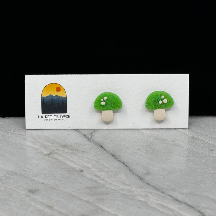 Pair of La Petite Rose Polymer Clay Green Mushroom Stud Earrings, on card