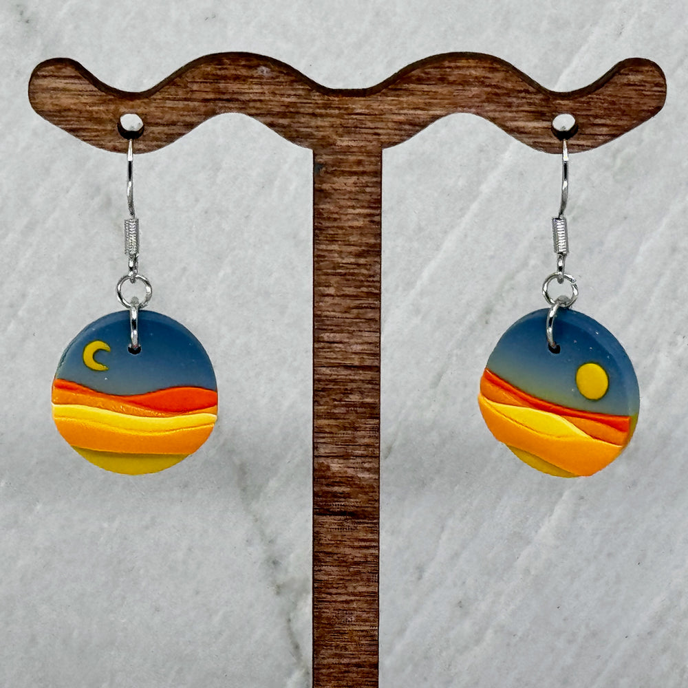 Pair of La Petite Rose's Big Sky Montana Sun Moon Landscape Clay Earrings (blue), hanging