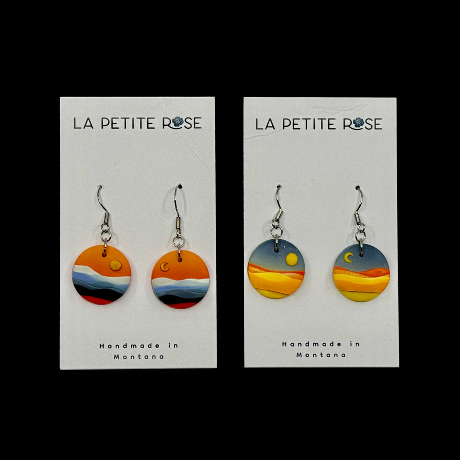 2 pairs of La Petite Rose's Big Sky Montana Sun Moon Landscape Clay Earrings (orange or blue), on cards
