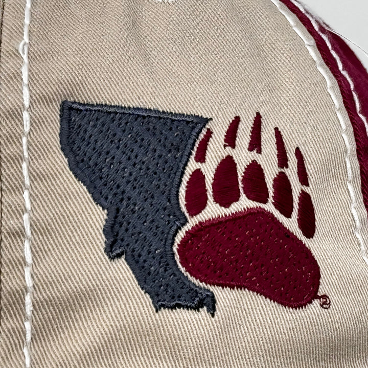 Blue Peak Creative's khaki and maroon Distressed Rambler Hat embroidered with the Montana Paw design in charcoal grey and maroon (detail)