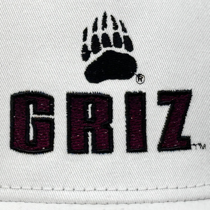 Blue Peaks Creative's black and white Surfer Trucker Hat embroidered with the Griz Block Small Paw design in maroon and black (detail)