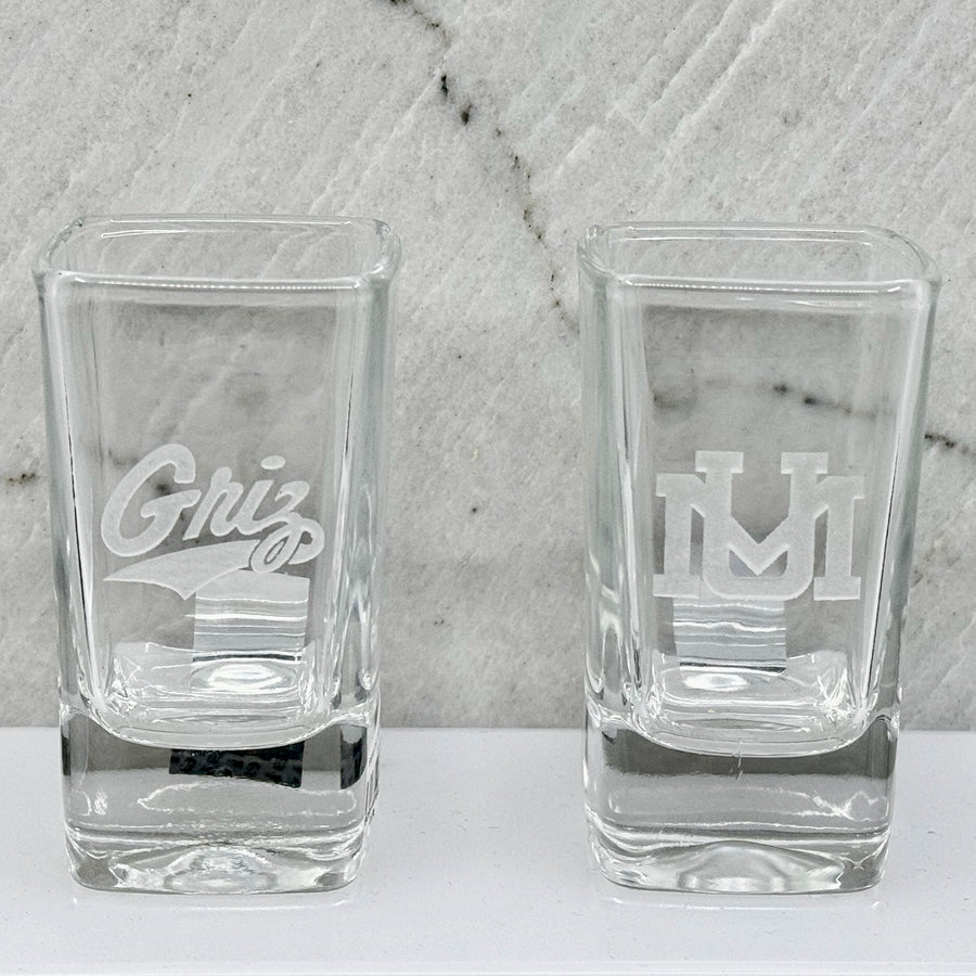 Blue Peaks Creative University of MT etched square shot glasses, two versions: UM logo and Griz Script
