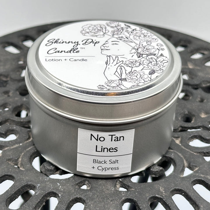 4 oz. tin of Skinny Dip Candle's No Tan Lines (black salt & cypress) Lotion + Candle, front