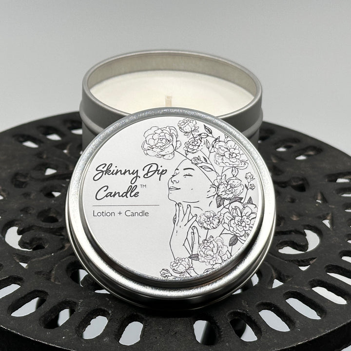 4 oz. tin of Skinny Dip Candle's Between the Sheets (cotton, violet & sandalwood) Lotion + Candle, lid & inside