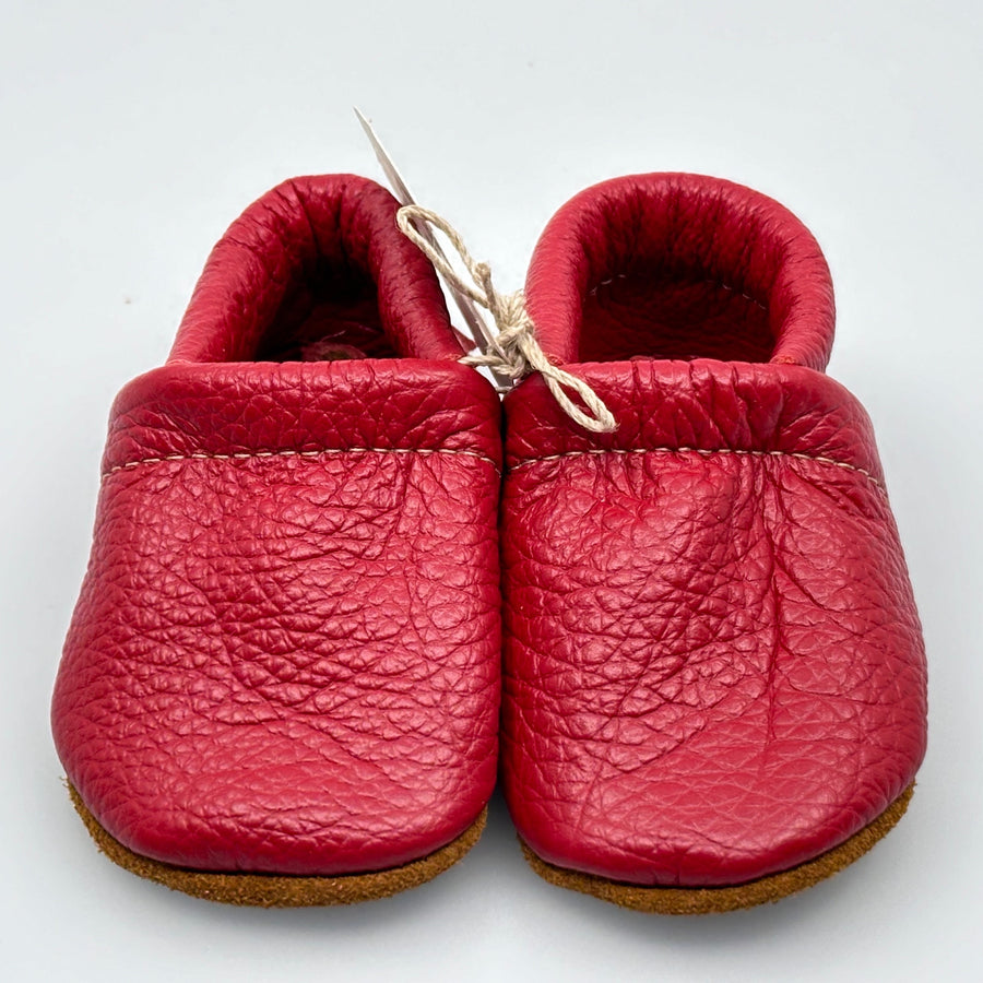 Pair of Starry Knight Design leather moccasins / baby booties, cherry red with fringe, front