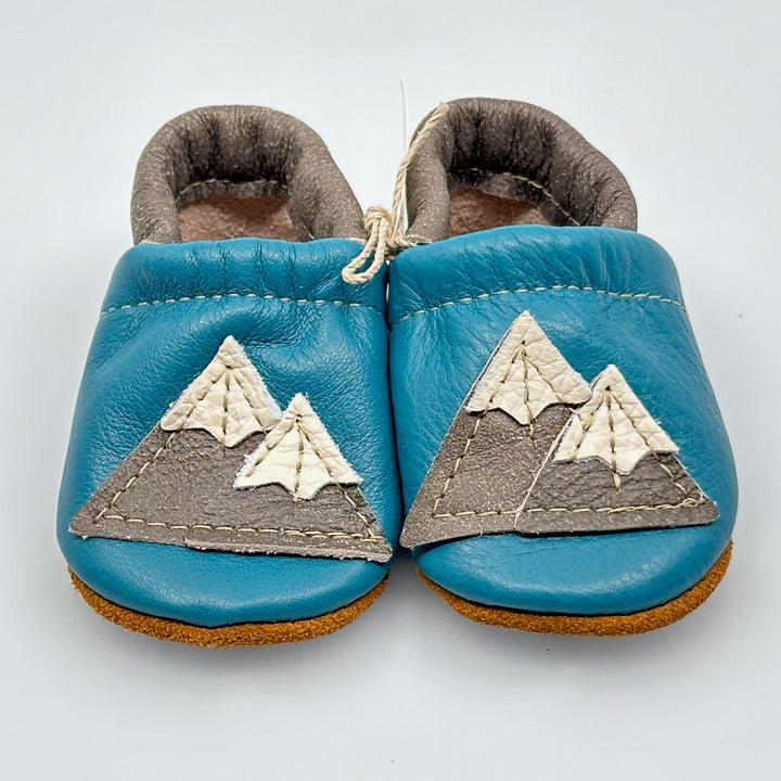 Pair of Starry Knight Design leather moccasins / baby booties, azure & cerulean with mountain design, front