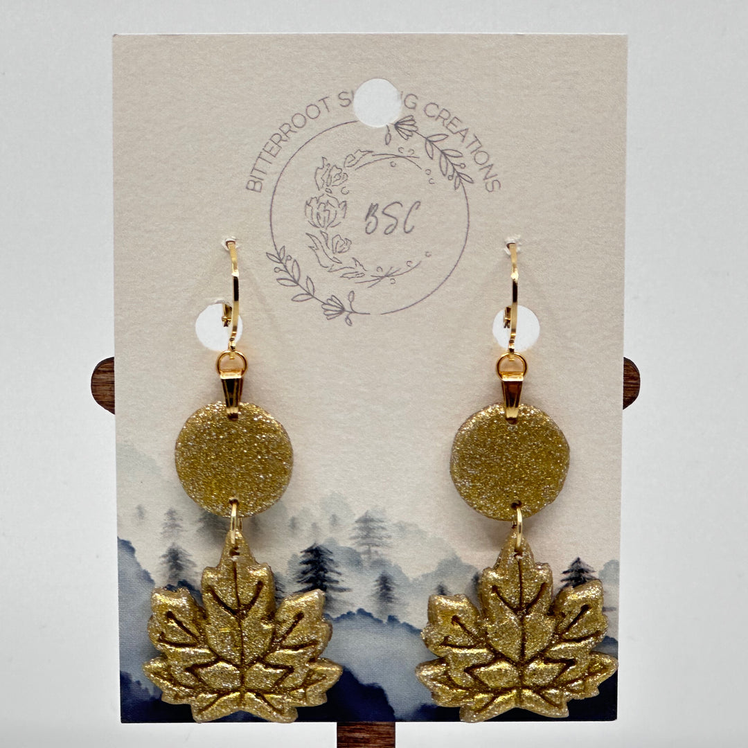 Bitterroot Shining Creations metallic Maple Leaf Earrings on card, gold color