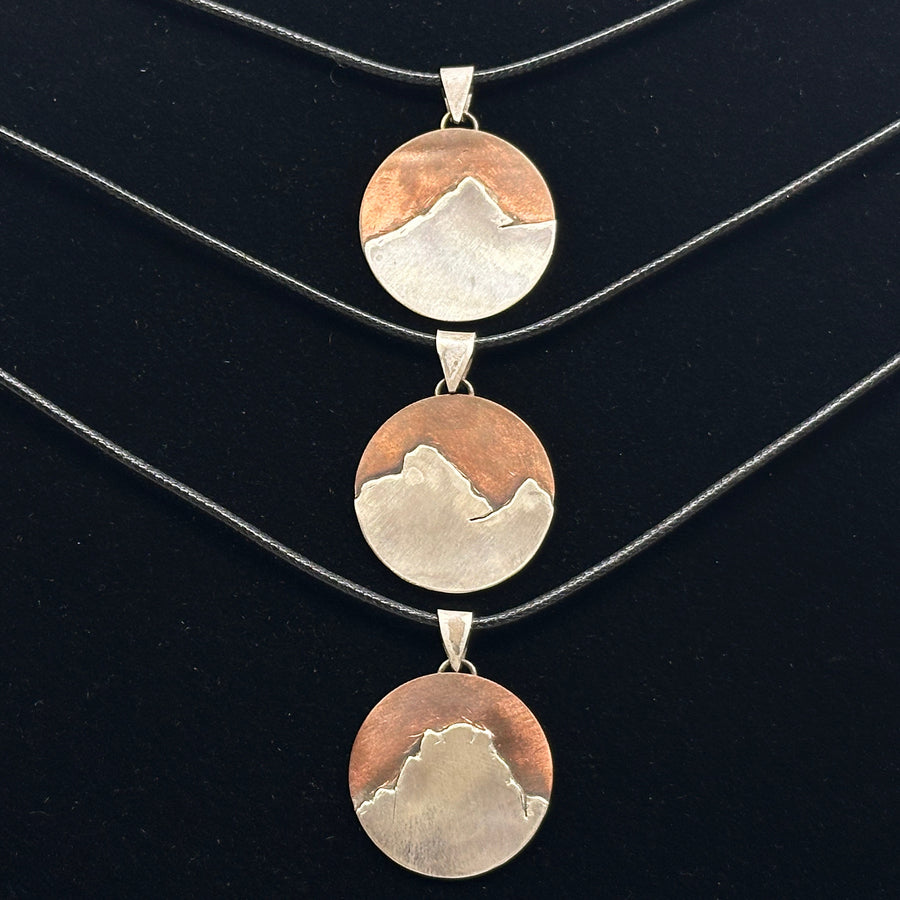 Three Bull & Bear's Copper and .925 Sterling Silver Montana Mountain Pendants, featuring various peaks in Montana, on black cords