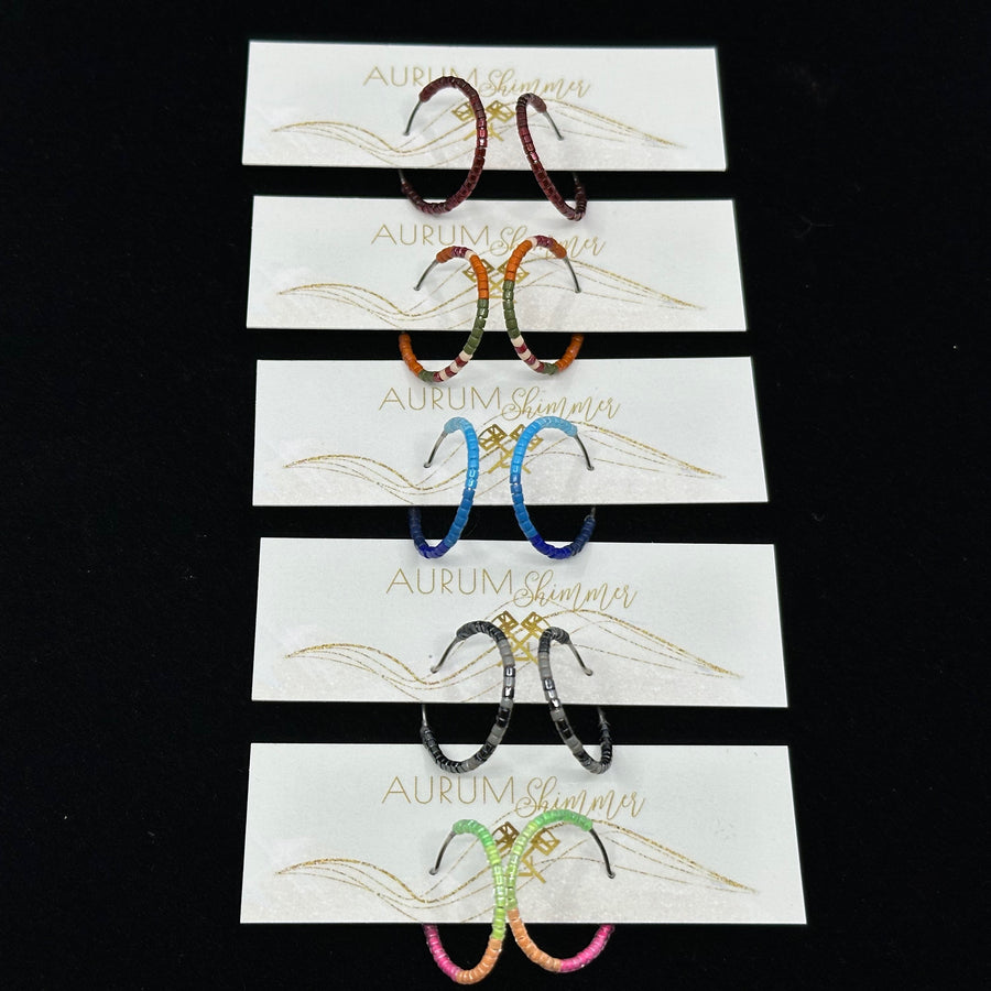 Five pairs of Aurum Shimmer's Beaded Stainless Steel Hoop Earrings (assorted colors), on cards