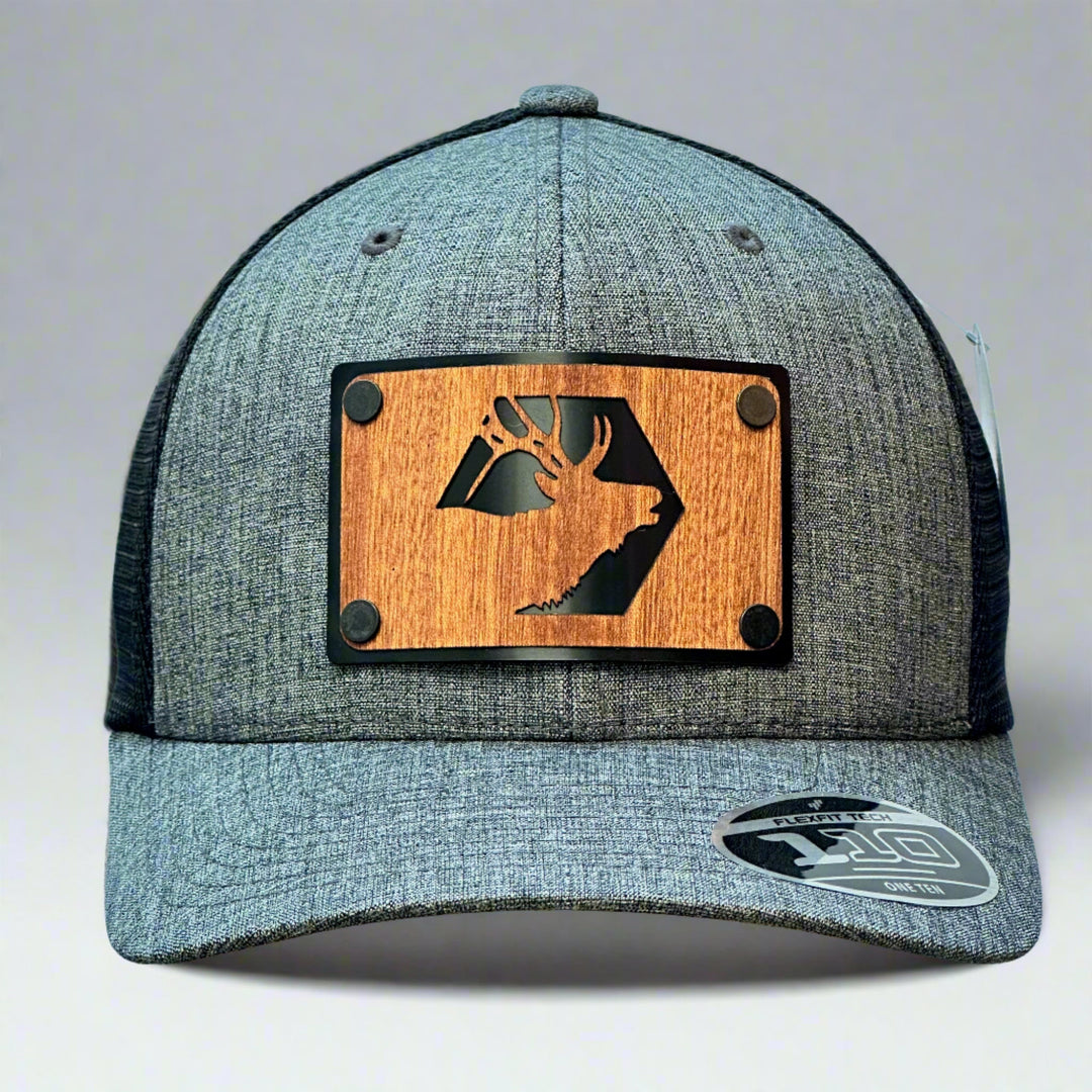 A grey and black flex fit trucker hat with a elk wood patch in mahogany.