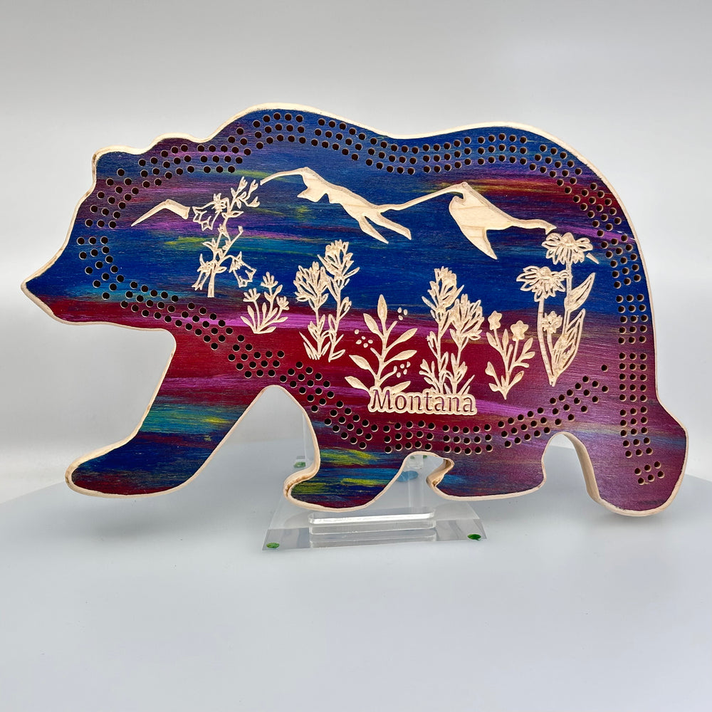 Knotty Pineworks Bear Cribbage Board with Montana Wildflowers (sunset tones with light accents)—this handmade wooden cribbage board is the perfect Montana-made gift for game lovers and adventurers 