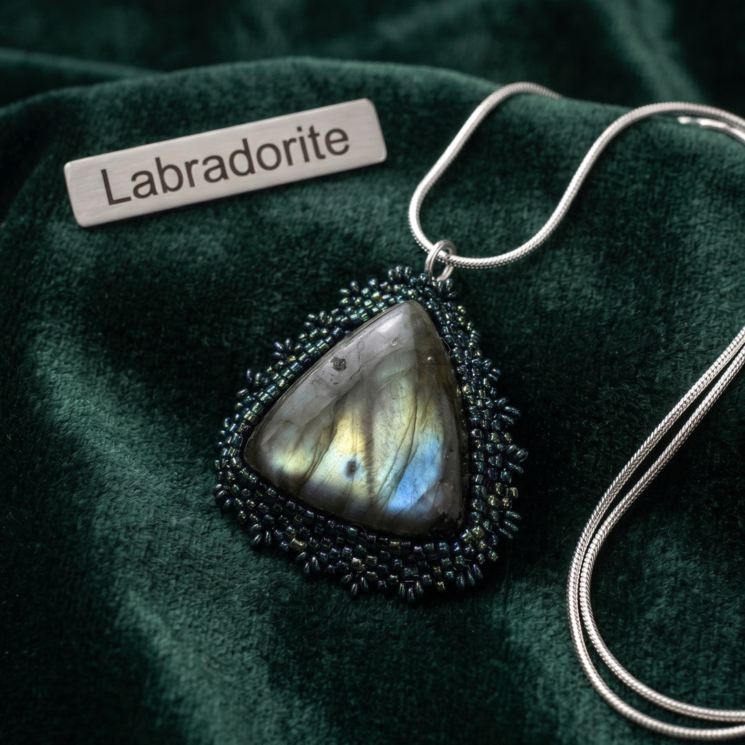 Labradorite hand beaded pendant necklace on a green fabric background with &